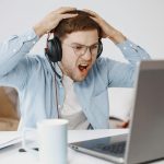 Guy sitting at his computer looking shocked and angry